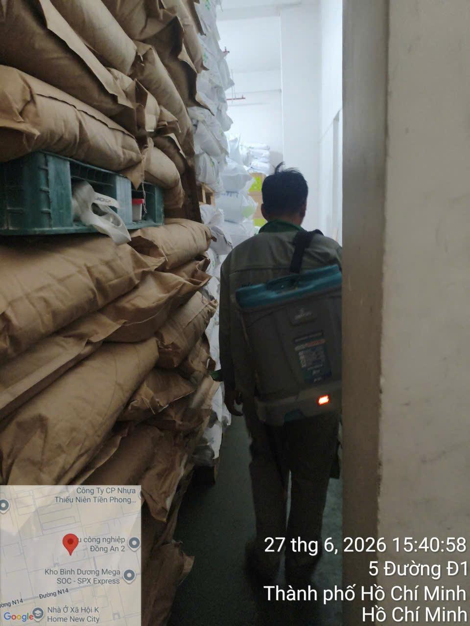 Phun xử lý quanh chồng thùng carton đặt trên pallet tại nhà xưởng có mái cao