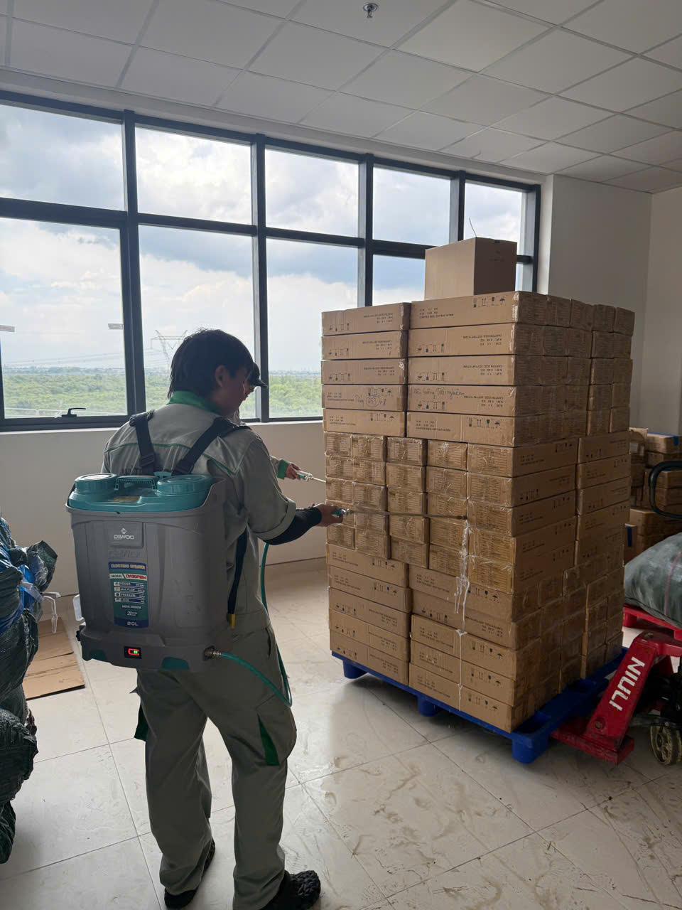 Phun xử lý quanh chồng thùng carton đặt trên pallet tại một cơ sở đang có hợp đồng định kỳ
