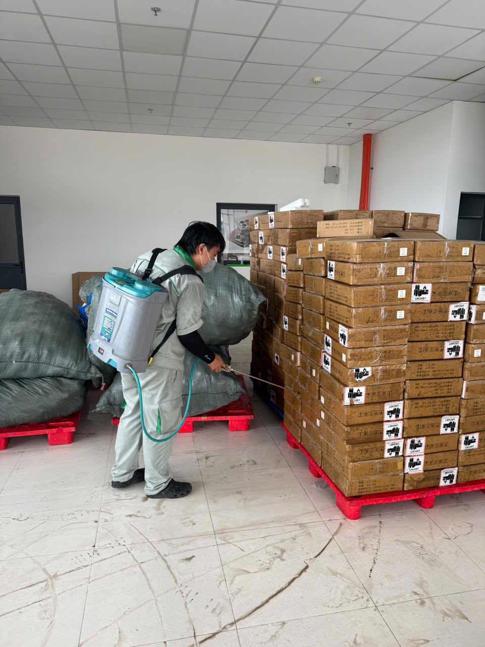 Phun xử lý dọc lối giữa các pallet thùng carton trong kho trong một đợt xử lý có lập hồ sơ