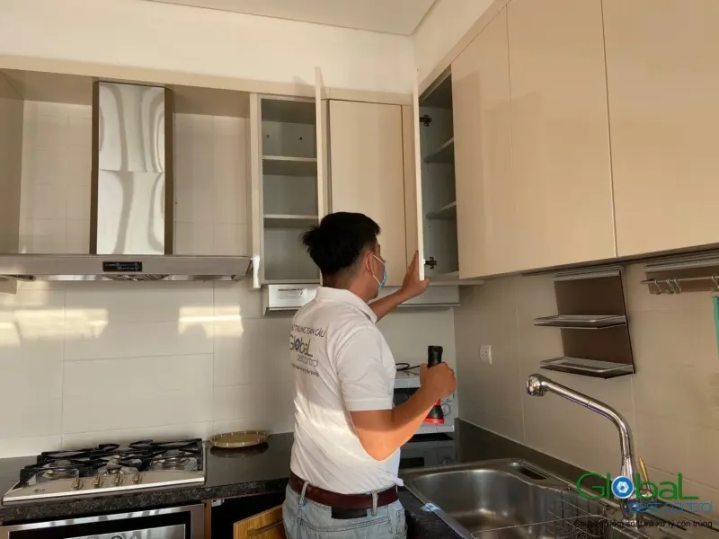 Kỹ thuật viên kiểm tra tủ bếp treo tường trong căn hộ