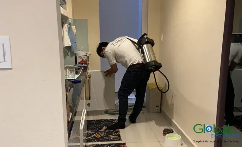 Kỹ thuật viên phun xử lý trong hành lang căn hộ