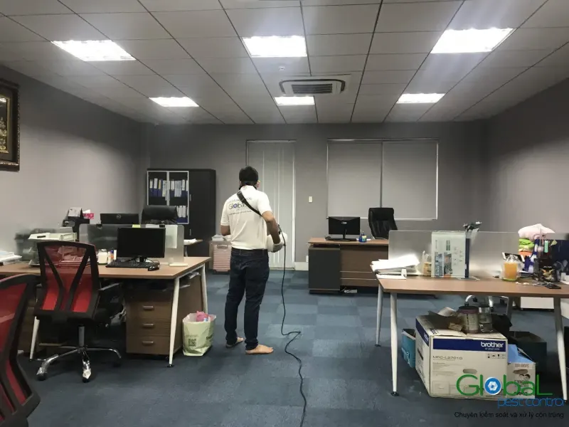 Kỹ thuật viên phun sương khu bàn làm việc lúc văn phòng vắng người, trong một lượt kiểm hằng tháng