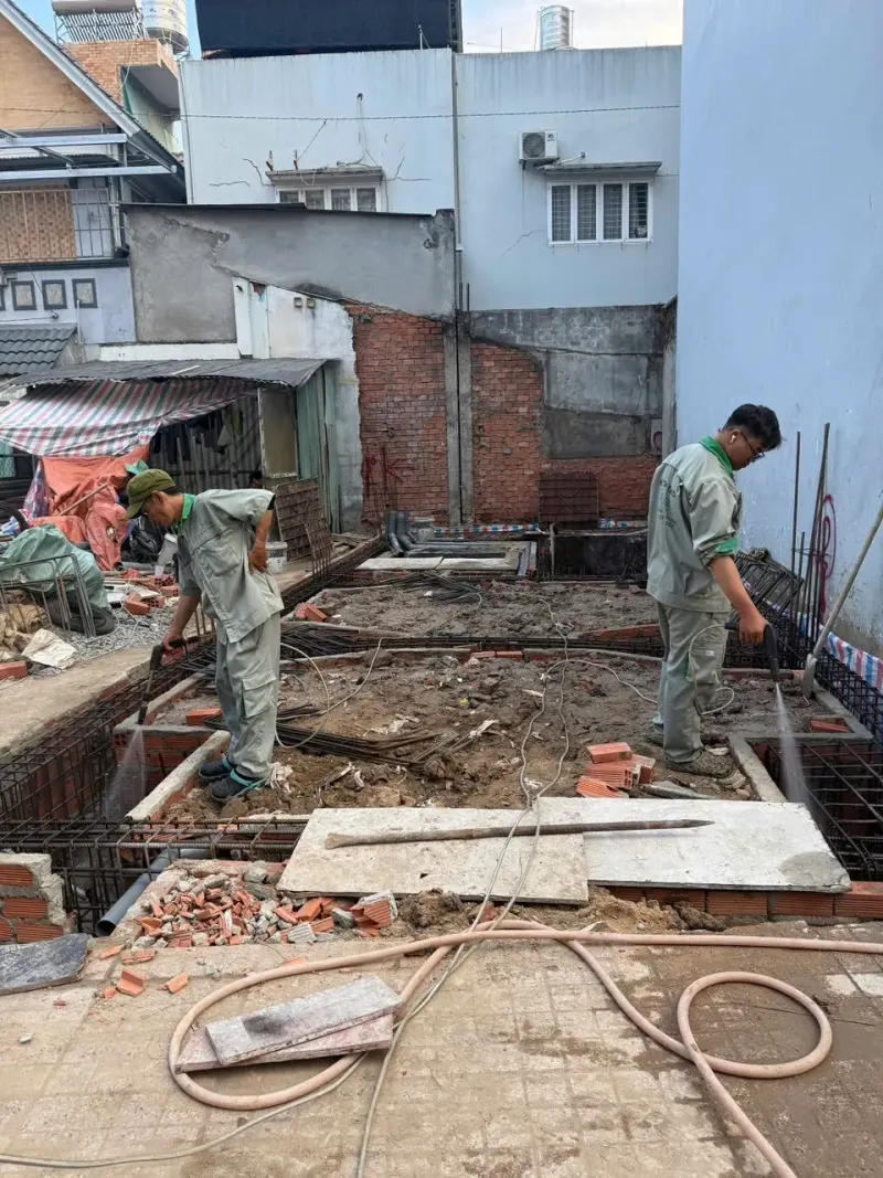 Công nhân phun thuốc chống mối nền đất công trình đang xây, xử lý mối đất nền