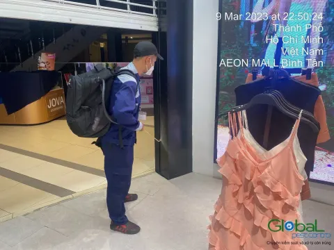 Kỹ thuật viên đeo bình phun xử lý côn trùng cửa hàng thời trang trong trung tâm thương mại