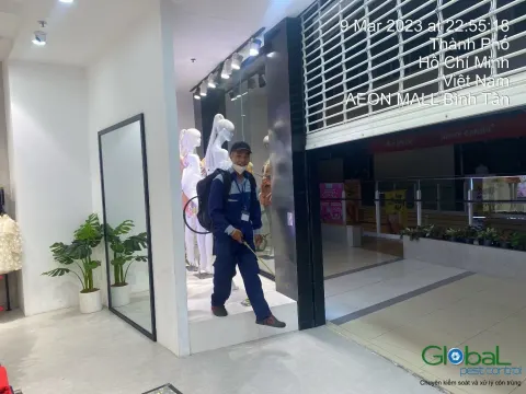 Kỹ thuật viên phun thuốc diệt côn trùng cửa hàng thời trang trong trung tâm thương mại