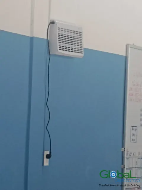 Đèn diệt côn trùng gắn tường cạnh bảng thông tin, dây cấp điện đi thẳng xuống ổ cắm