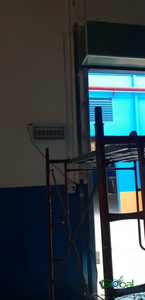 Đèn diệt côn trùng lắp trên khung cửa sổ nhìn ra khu sản xuất