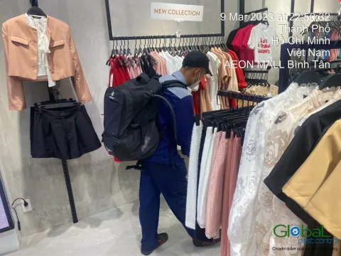 Kỹ thuật viên phun thuốc quanh giá treo quần áo trong cửa hàng thời trang