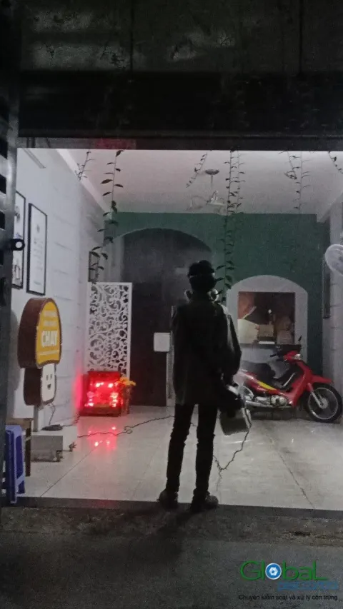 Kỹ thuật viên phun thuốc diệt côn trùng lối vào quán về đêm