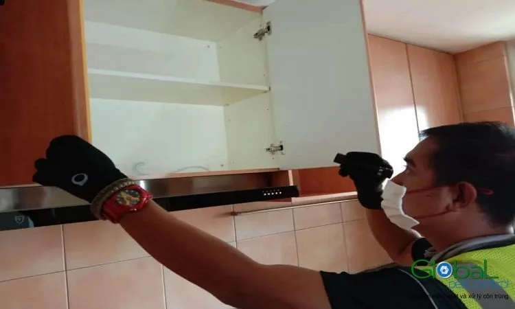 Kỹ thuật viên soi đèn kiểm tra khe tủ bếp treo