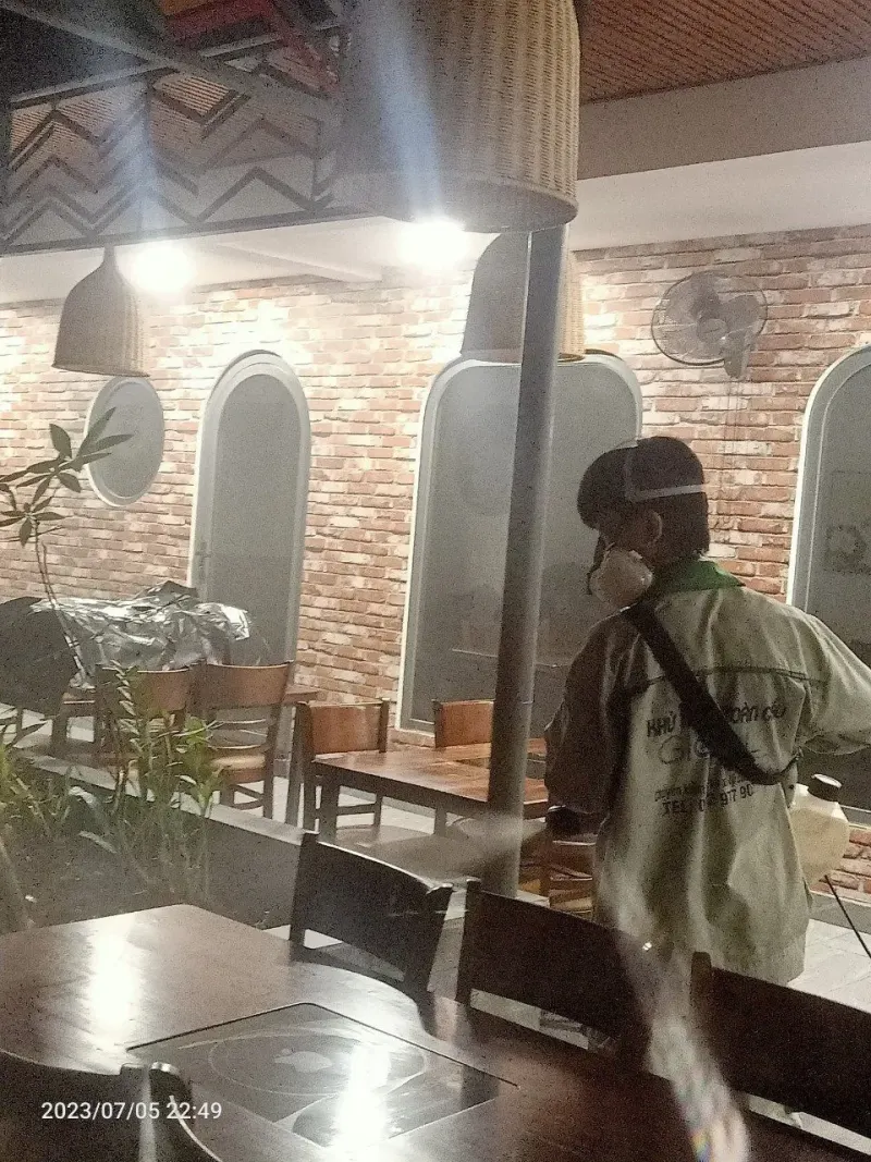 Kỹ thuật viên phun xử lý trong khu vực bàn ăn nhà hàng