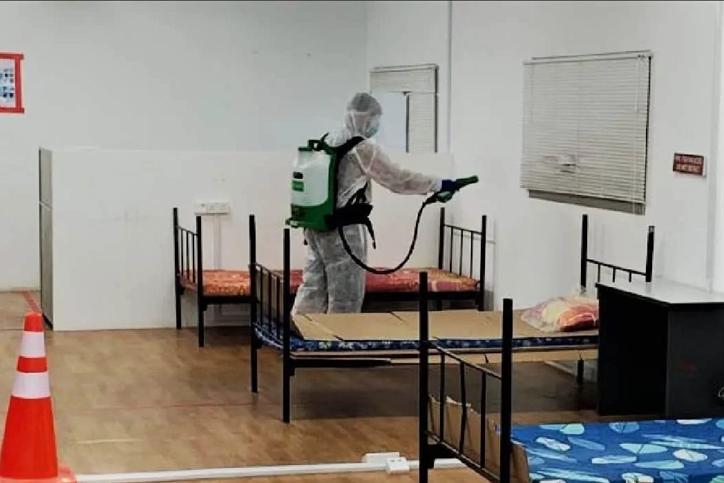 Kỹ thuật viên phun khử khuẩn phòng ở có giường tầng