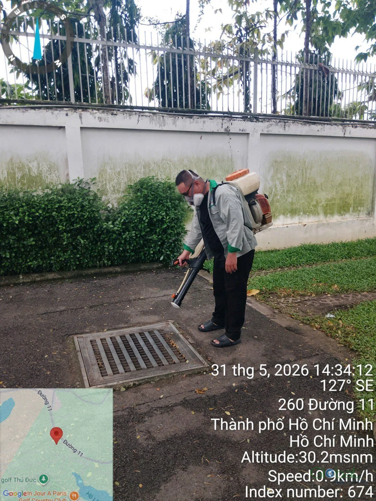 Kỹ thuật viên phun xử lý khu vực sân và cây cảnh quanh nhà