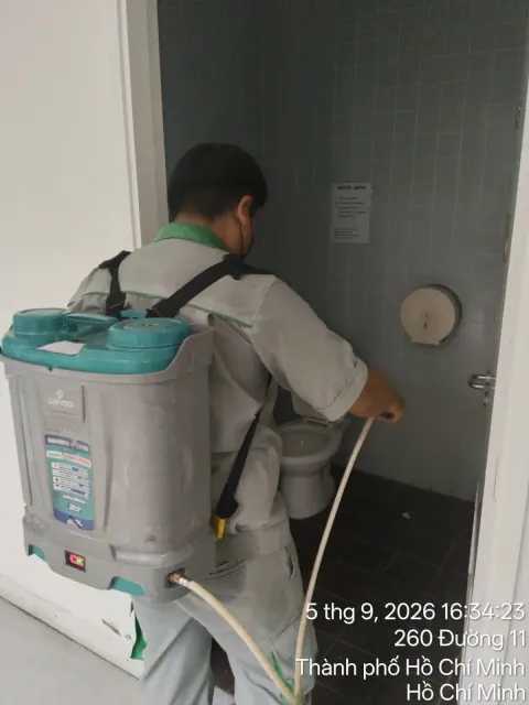 Kỹ thuật viên đeo bình phun điện phun thuốc nhà vệ sinh, phun định kỳ