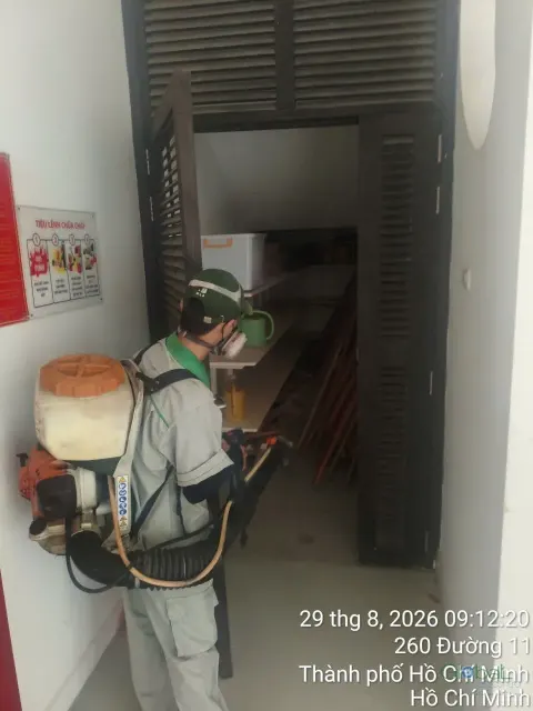 Kỹ thuật viên phun thuốc góc cầu thang thoát hiểm trường học