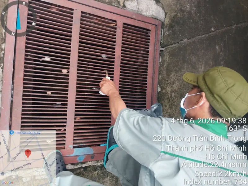 Kỹ thuật viên xử lý chế phẩm tại miệng hố ga trước cơ sở