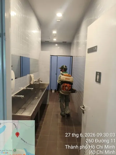Kỹ thuật viên phun thuốc diệt côn trùng nhà vệ sinh trường học