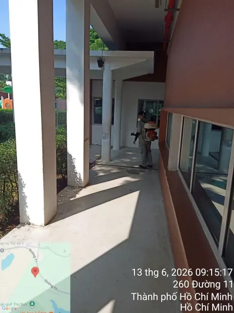 Kỹ thuật viên phun thuốc diệt côn trùng hành lang lớp học