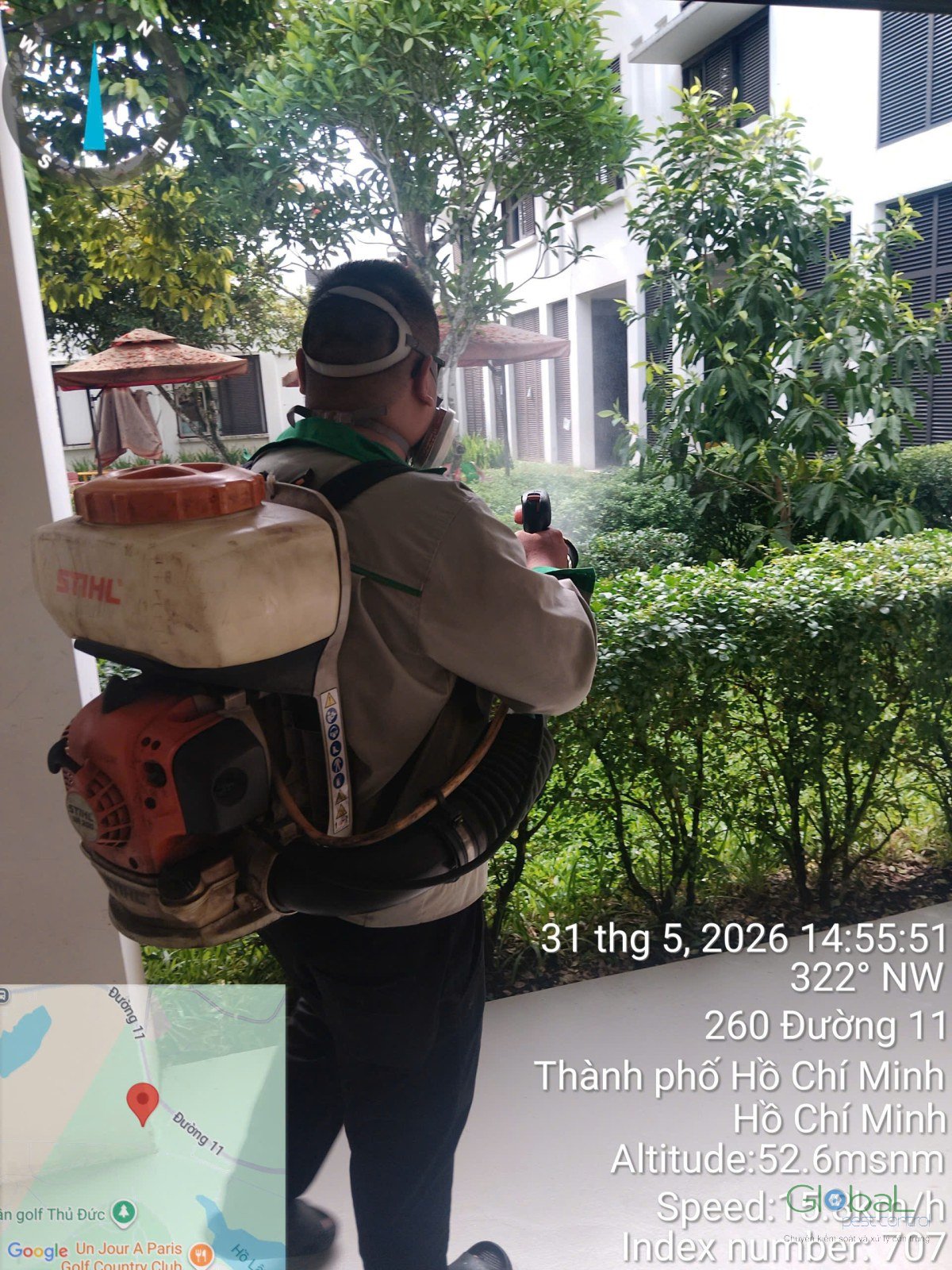 Kỹ thuật viên phun xử lý bụi cây trong khuôn viên
