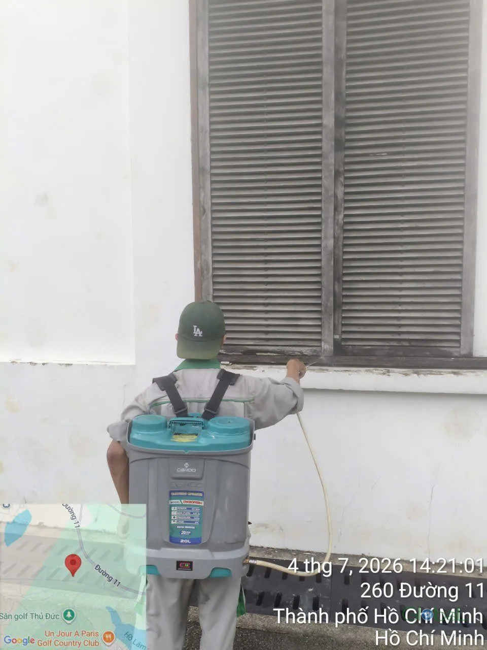 Kỹ thuật viên xử lý chân tường phía ngoài toà nhà