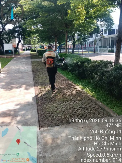 Kỹ thuật viên phun thuốc diệt muỗi khu vườn và lối đi lát gạch