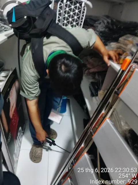 Kỹ thuật viên phun thuốc góc kệ trưng bày cửa hàng bán lẻ
