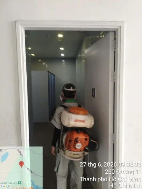 Kỹ thuật viên đeo máy phun động cơ phun thuốc nhà vệ sinh trường học
