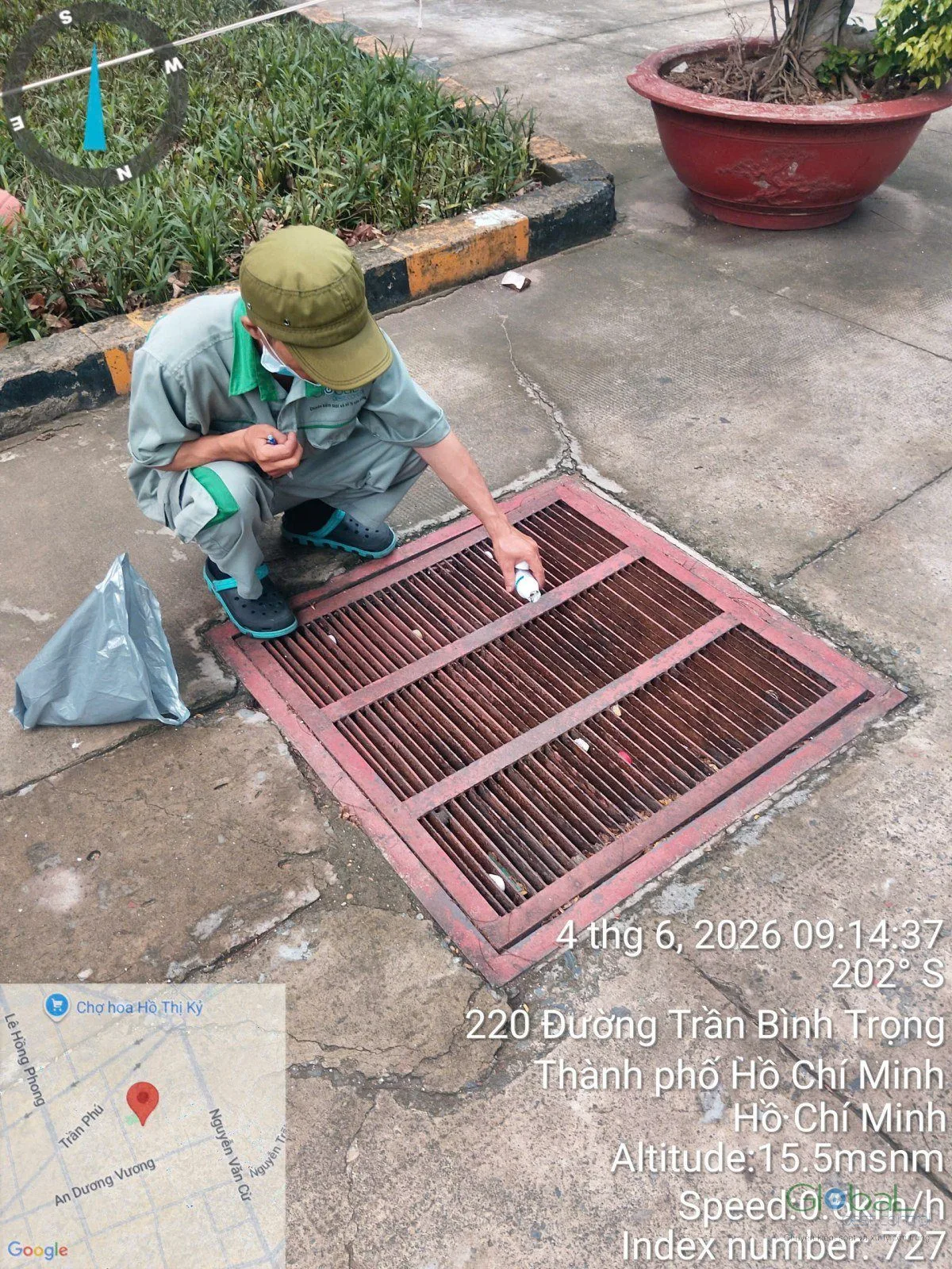 Kỹ thuật viên xử lý hố ga trên nền sân
