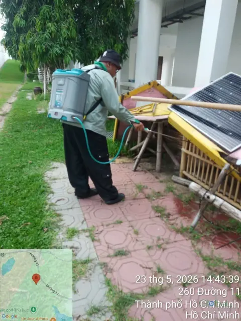 Kỹ thuật viên phun thuốc diệt muỗi khu vật liệu để ngoài trời cạnh bãi cỏ