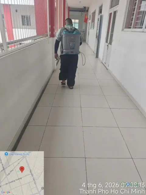 Kỹ thuật viên phun thuốc dọc hành lang dài dãy lớp học