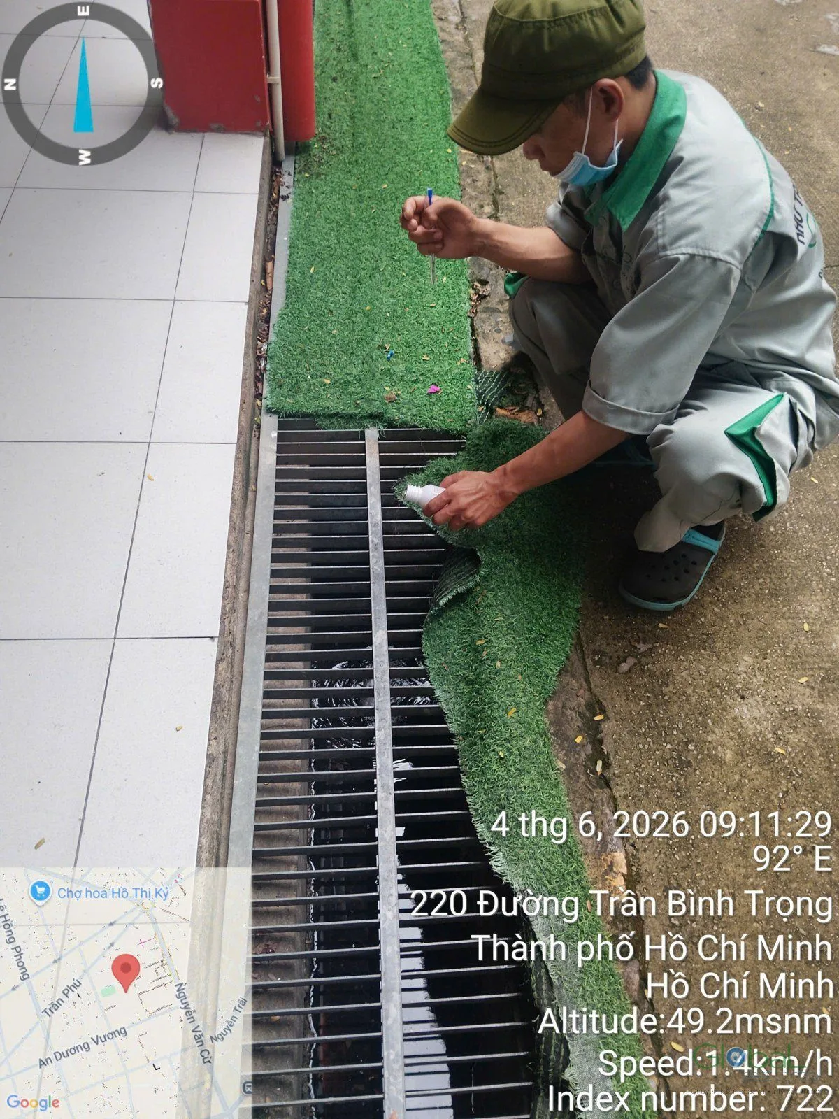 Kỹ thuật viên xử lý rãnh thoát nước có nắp đan bên hông nhà
