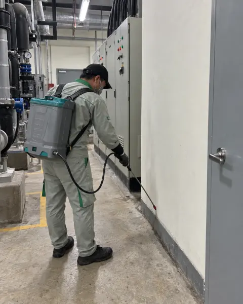 Kỹ thuật viên phun khe áp lực thấp dọc chân tường phòng cơ điện bệnh viện