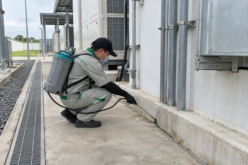 Kỹ thuật viên phun khe áp lực thấp dọc chân tường khu cơ điện nhà máy dược