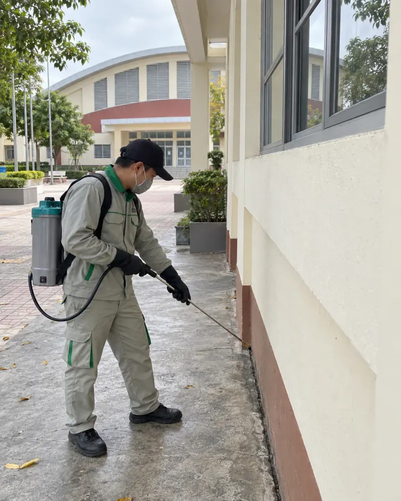 Kỹ thuật viên phun khe áp lực thấp dọc chân tường nhà đa năng trường học